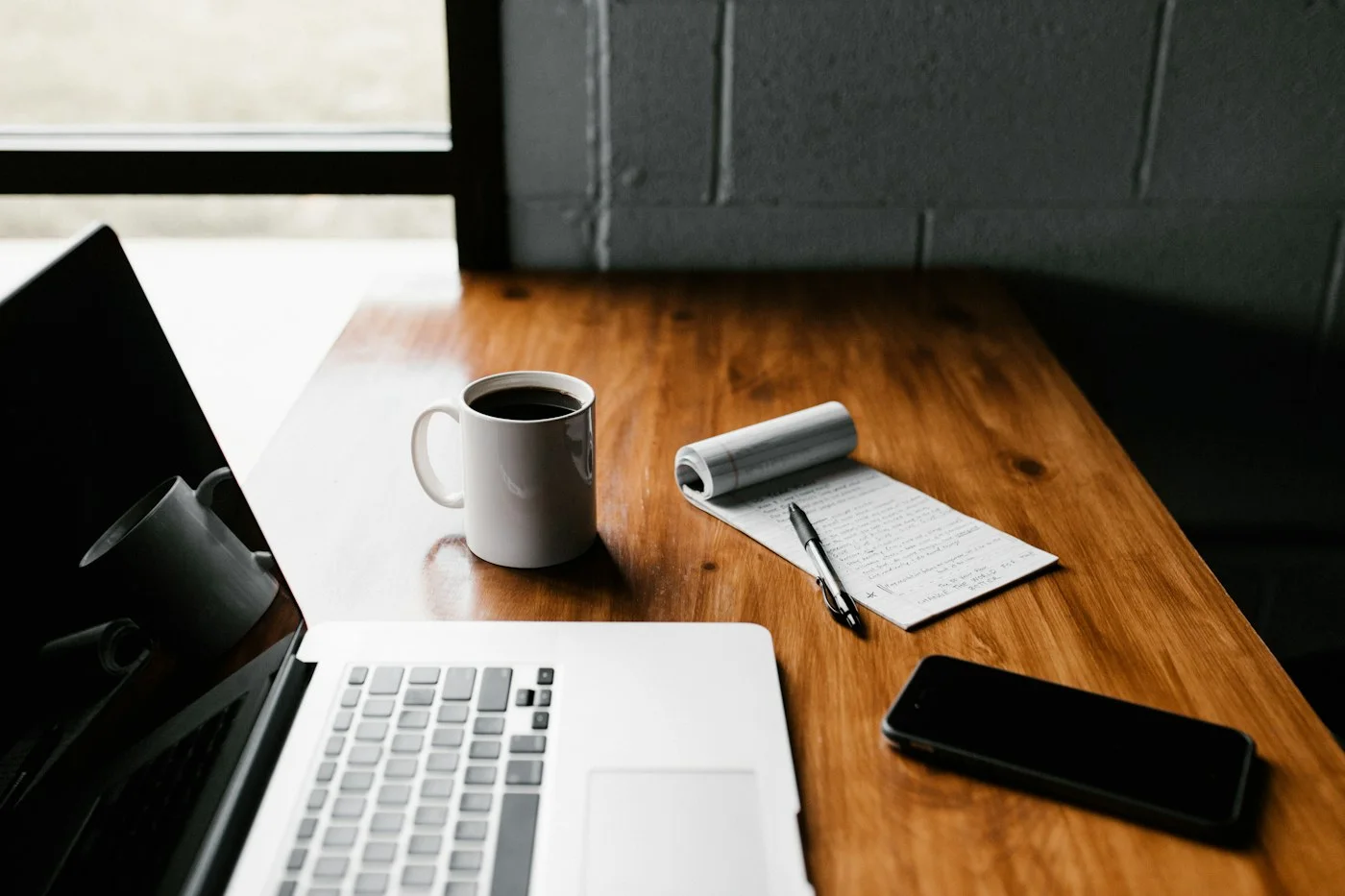 Notebook, pen, and coffee on a desk as a person reflects on OCD recovery goals