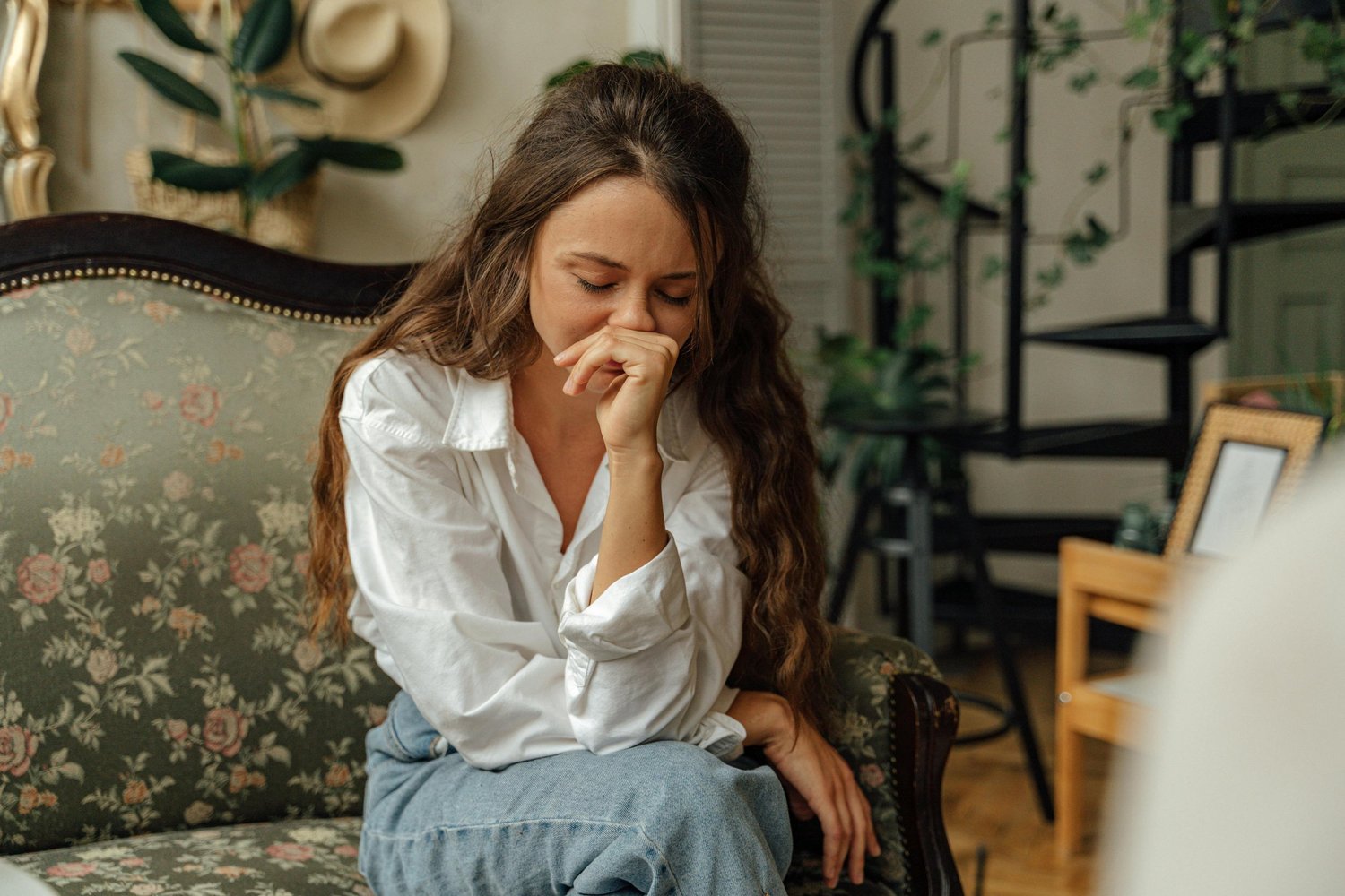 Woman sitting alone with her hand covering her mouth