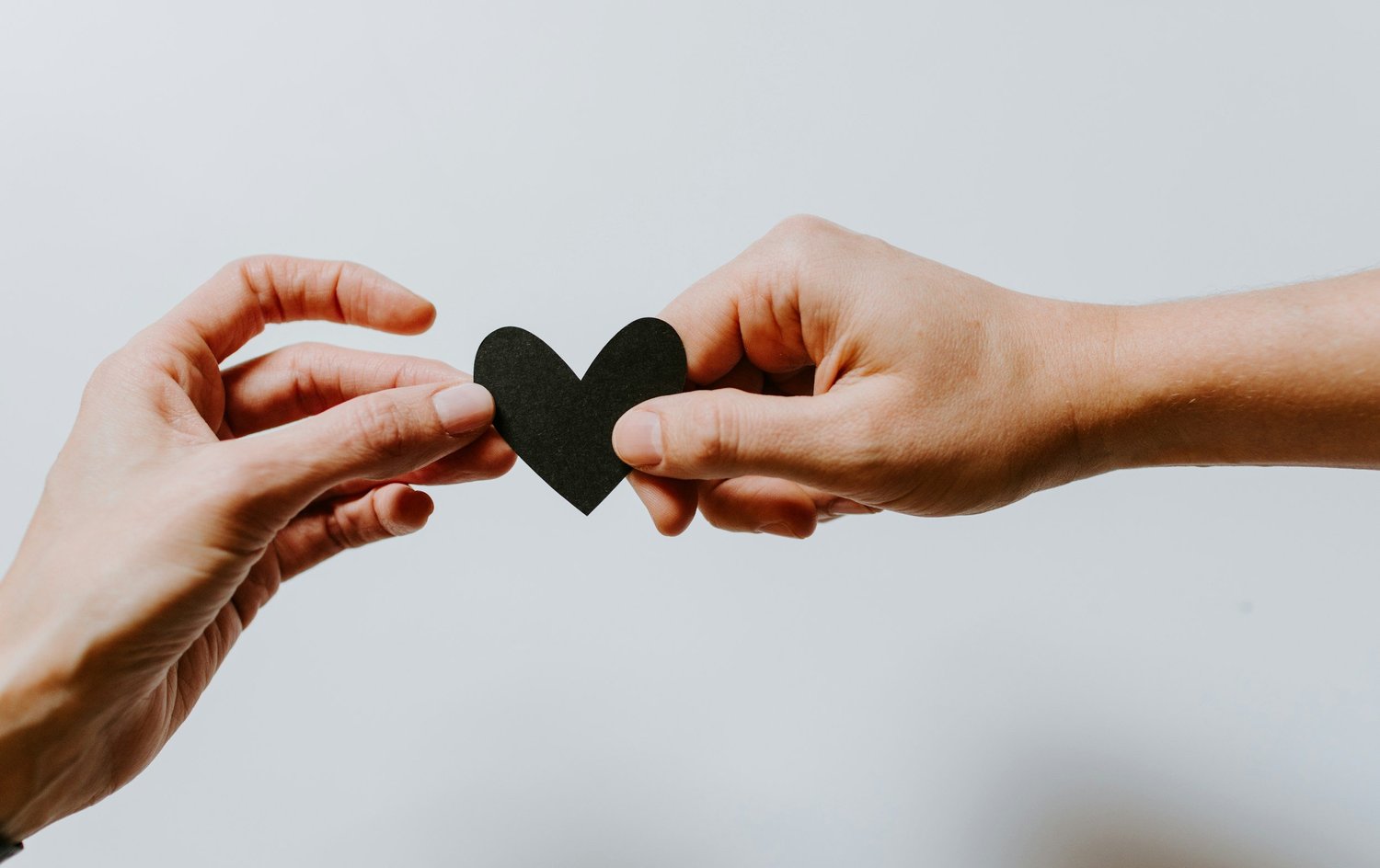 wo hands gently holding a heart, symbolizing love, connection, and emotional healing in relationships.