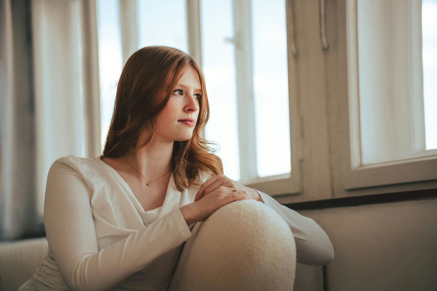 Woman sitting thoughtfully, reflecting on intrusive thoughts and mental health wellness