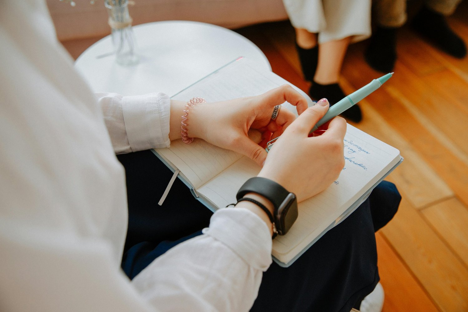 Hands writing in a journal under warm natural light for mindfulness and emotional clarity