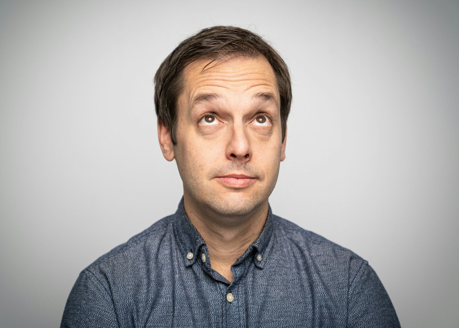 Man in a reflective pose looking upward illustrating contemplation and understanding of intrusive thoughts in OCD awareness