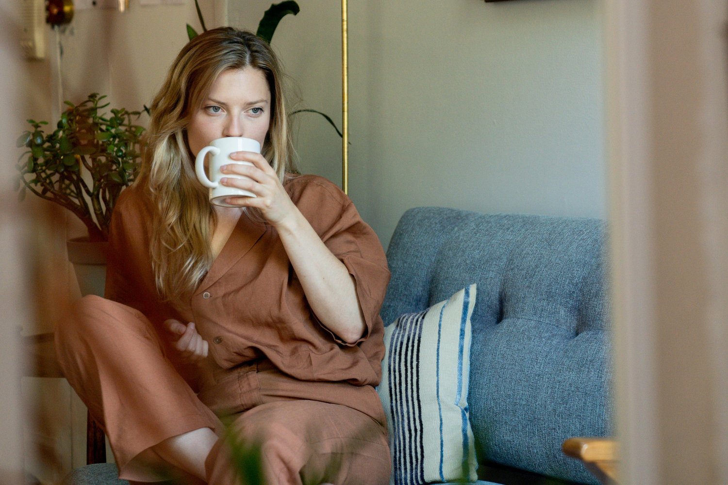 Woman holding a cup while sitting quietly on a sofa
