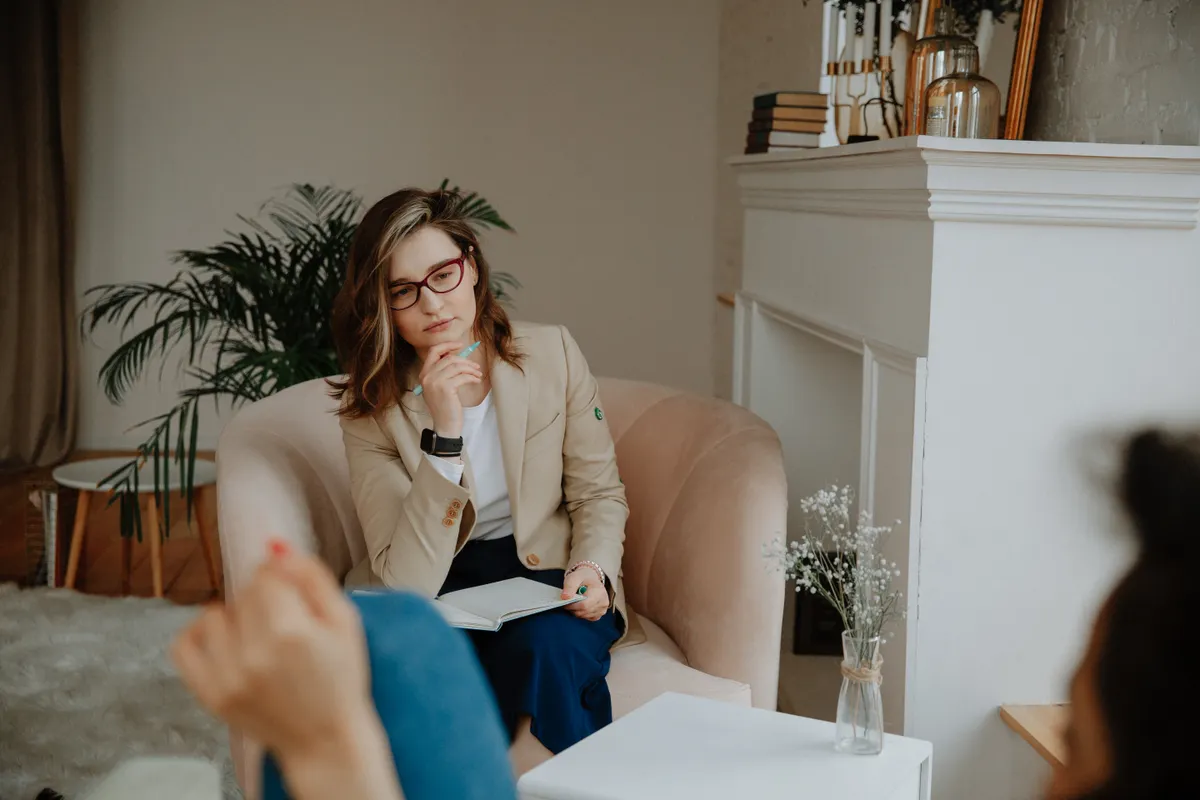 Therapist listening while a client speaks during a counseling appointment