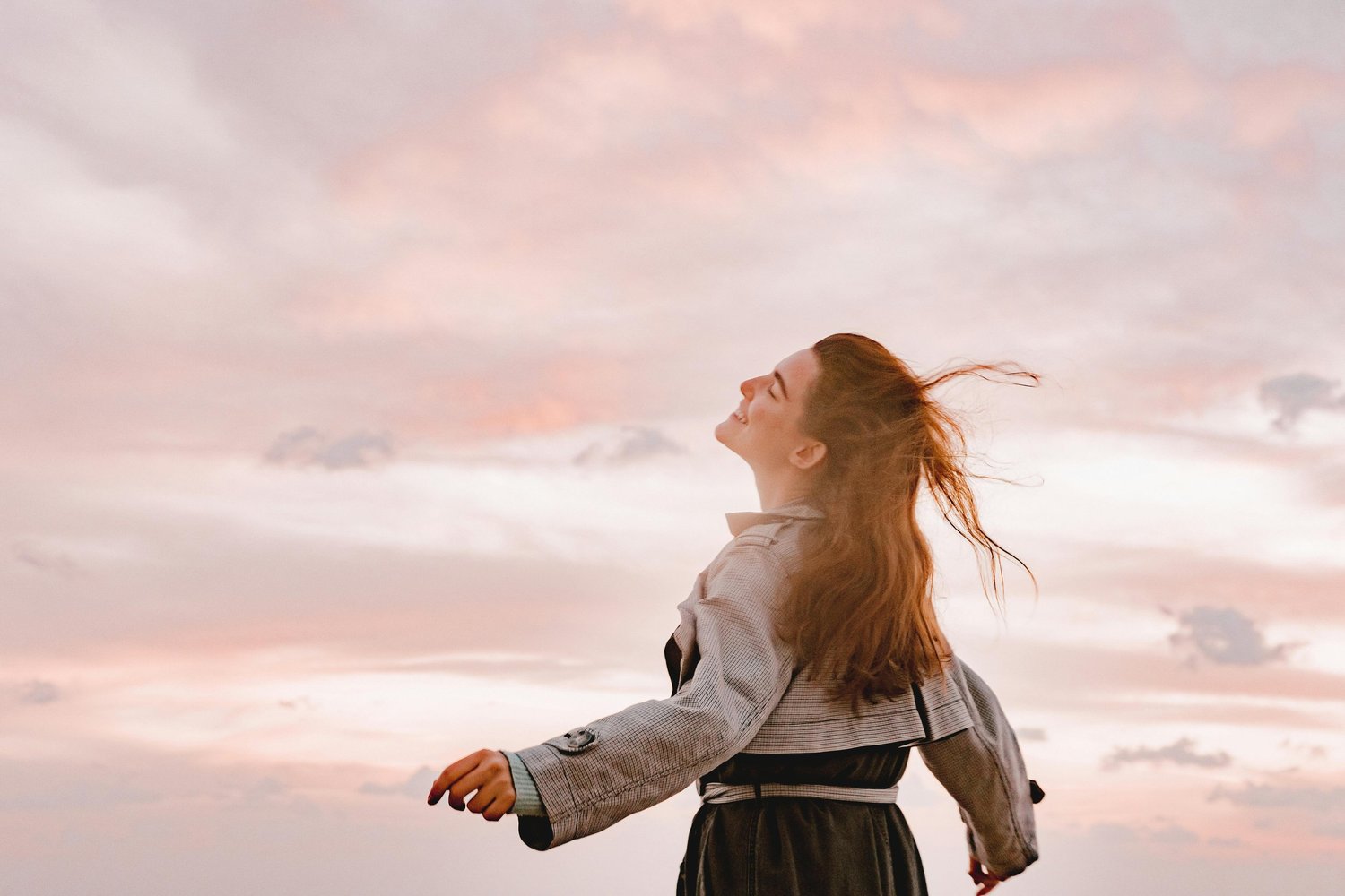 A woman standing outside in the Arizona sunshine, looking peaceful and carefree — symbolizing healing, freedom, and recovery from OCD.