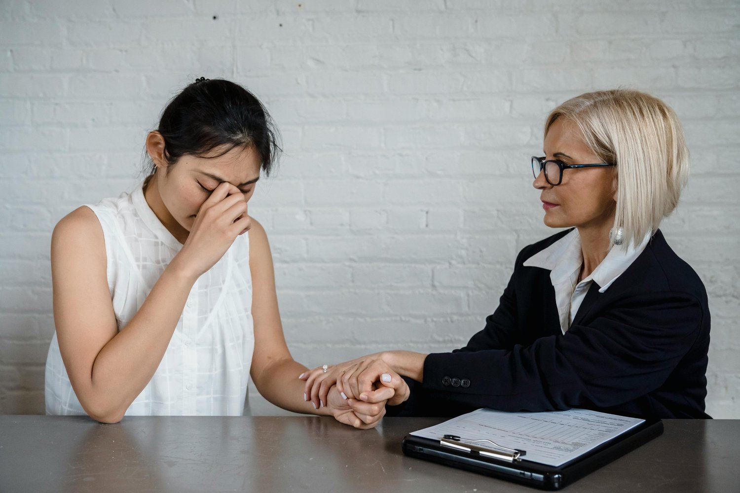Counselor holding the hand of a distressed client