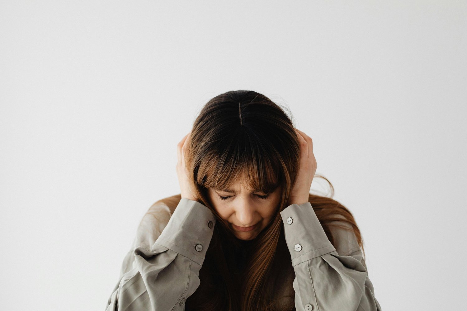 Person pressing their hands to the sides of their head