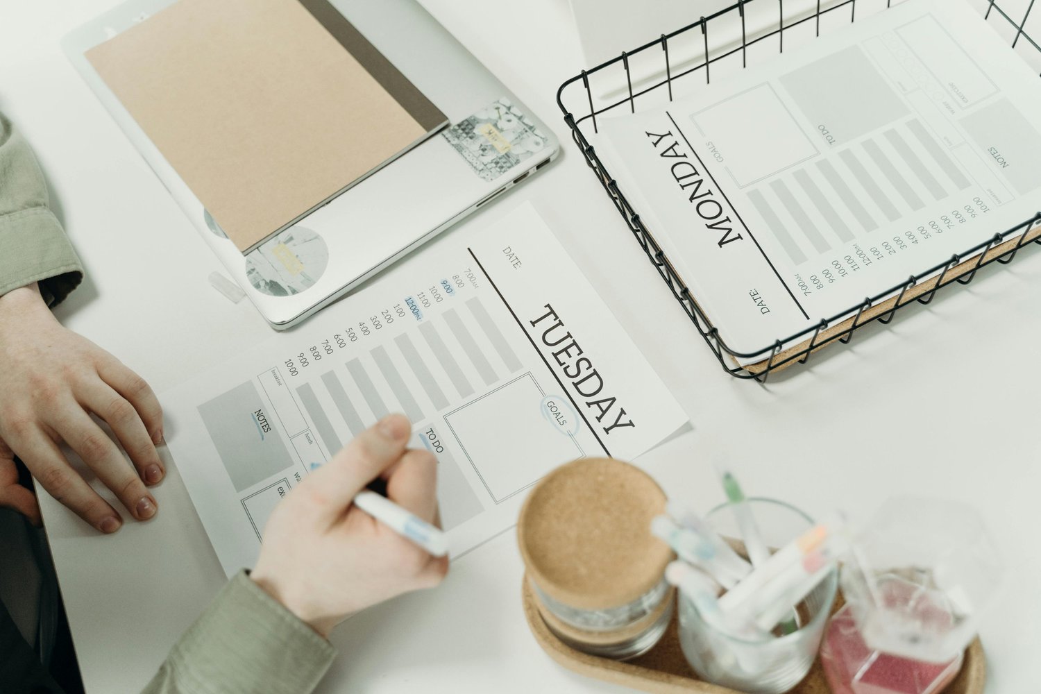 Woman writing in a planner at a neatly organized desk, illustrating planning, order, and perfectionism for OCD counseling and mental health wellness.