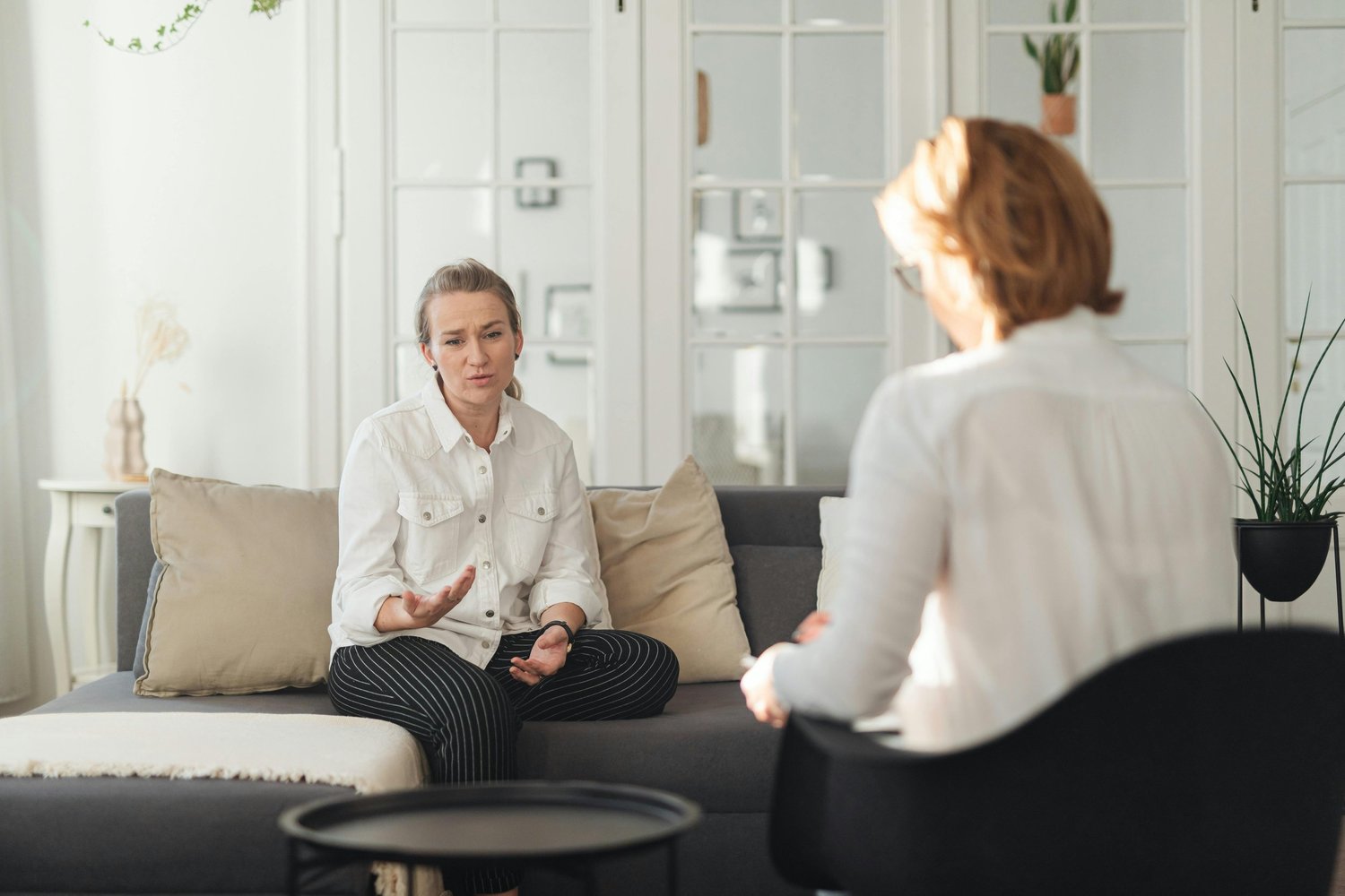 Woman sitting in a counseling session, discussing OCD and mental health concerns with a therapist in a supportive environment