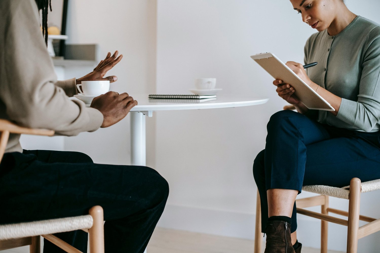 A man sits in a therapy session for OCD, talking with his therapist in a calm, supportive setting focused on managing intrusive thoughts and compulsive behaviors.