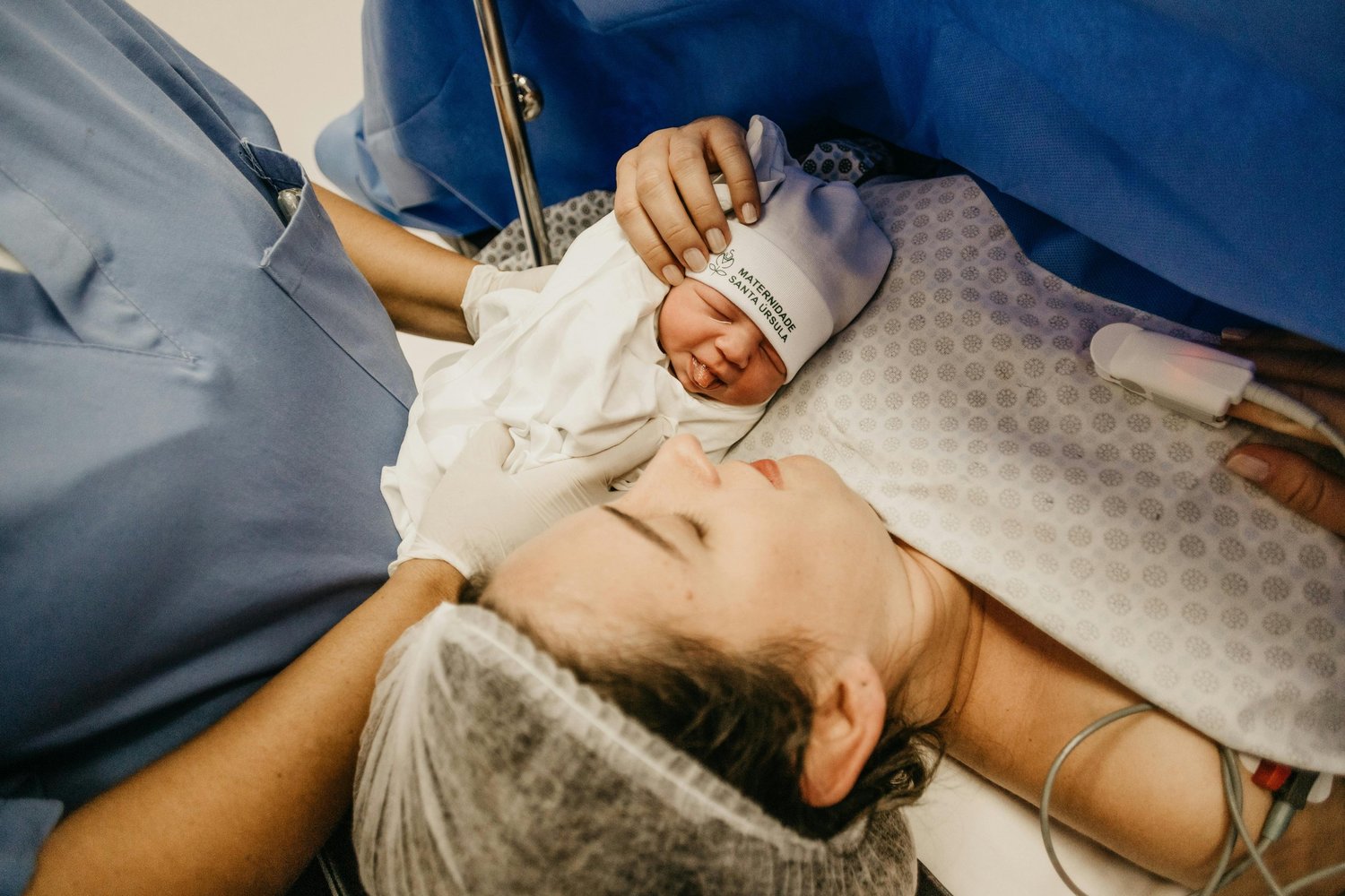 Parent resting with a sleeping newborn on their chest