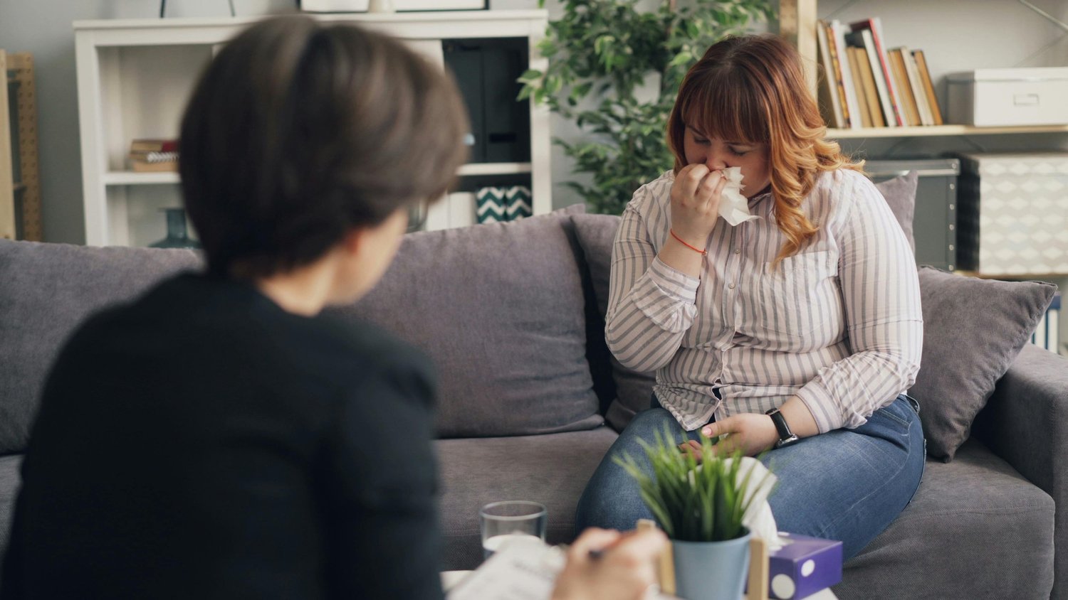 Woman talking with a counselor while seated on a sofa