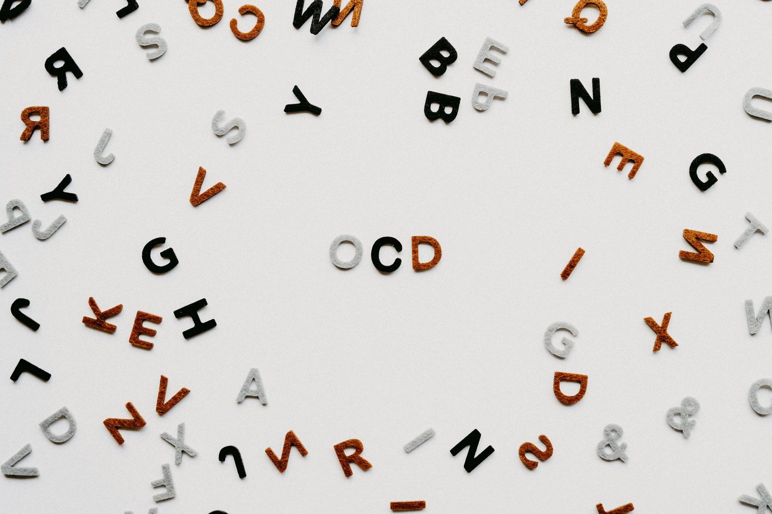 The letters OCD surrounded by scattered alphabet letters